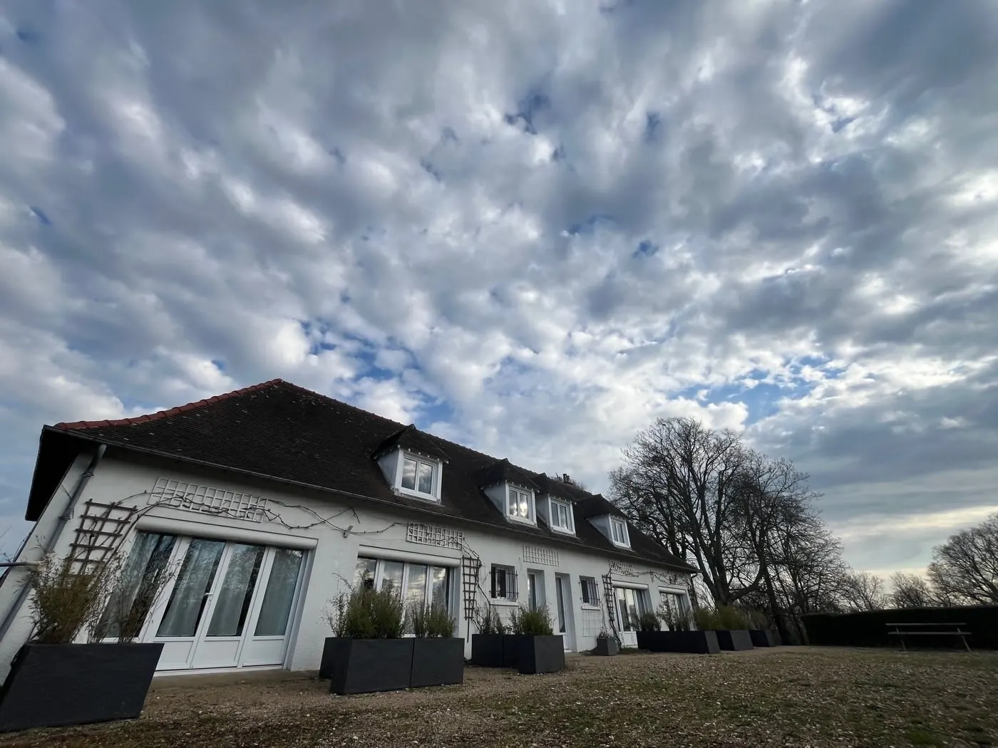 Bâtiment des chambres d'hôtes du Manoir de la Houlette sous le ciel normand — séminaire résidentiel